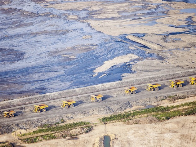Huge dump trucks lined up in 2012 to transport tar sand from a surface mine, Fort McMurray, Alberta 
