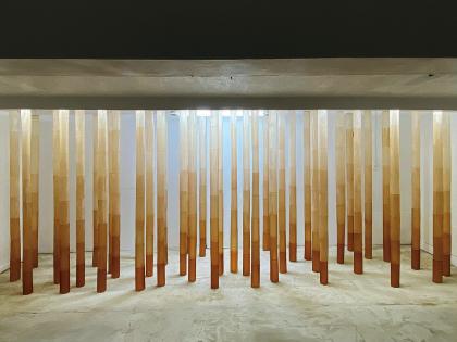 Yamamoto's installation, made of 20 orange tubes that stretch from floor to ceiling in a white room. 