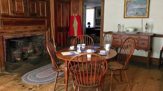 Kitchen at Whittier Birthplace with round wood table and 4 chairs and wood surround fireplace