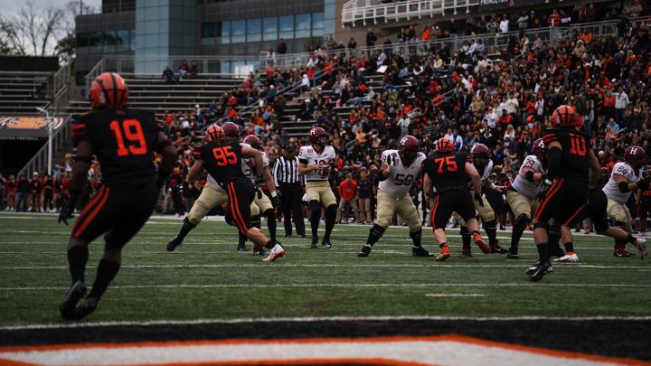 Harvard quarterback has the ball as Princeton players are in pursuit