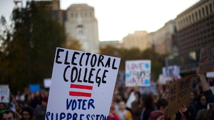 A protester holding a sign that reads "ELECTORAL COLLEGE = VOTER SUPPRESSION" on November 13, 2016.