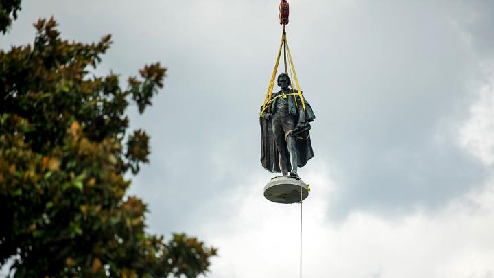 Photograph of John C. Calhoun statue in Charleston in midair being lifted up by a crane