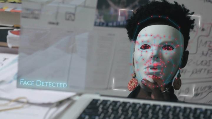 Joy Buolamwini dons a white mask in order to be visible to facial recognition software in the film Coded Bias.