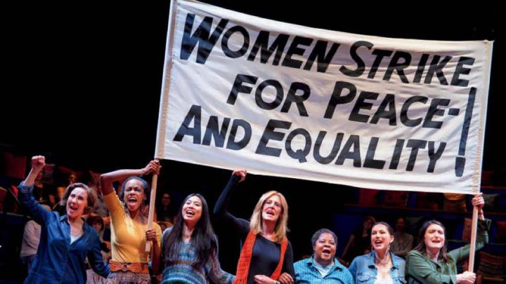 Scene from "Gloria, A Life," showing women marching in solidarity with protest sign