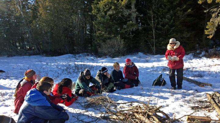 During downtime, students listen to guide Polly Mahoney read about life in the wilderness.