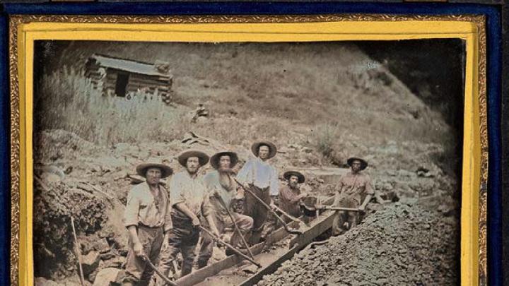 Gold miners working with a piece of gold-mining equipment called a long tom, circa 1850