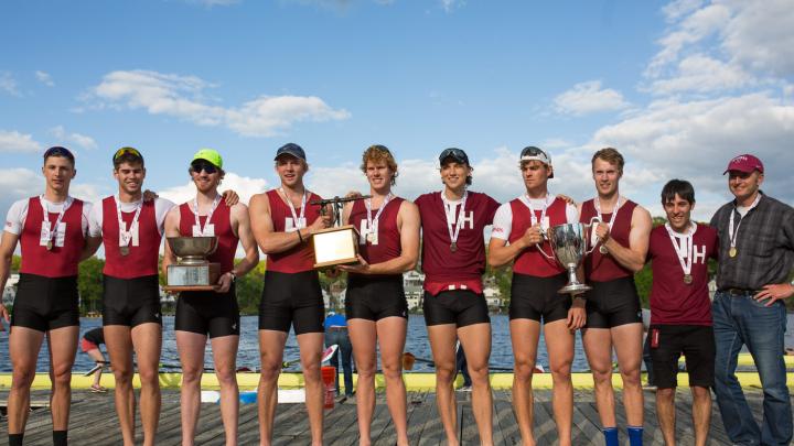 The varsity eight, wearing their gold medals on the dock