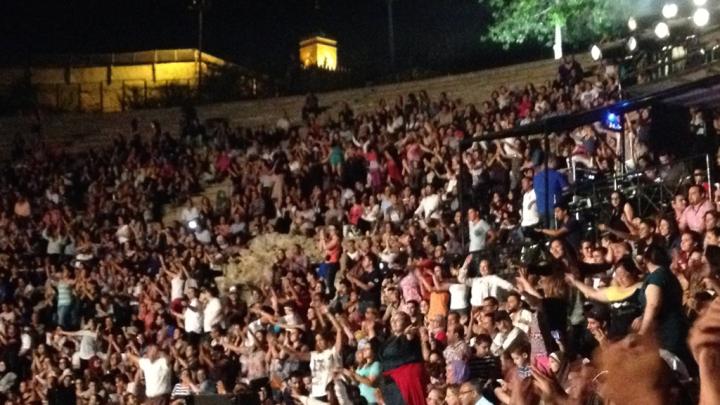 During Ramadan in Tunis, an undergraduate observes, the mood is celebratory and marked by a spirit of generosity. The photograph shows the audience dancing during a late-night traditional concert held at the Roman amphitheater in Carthage, Tunis.