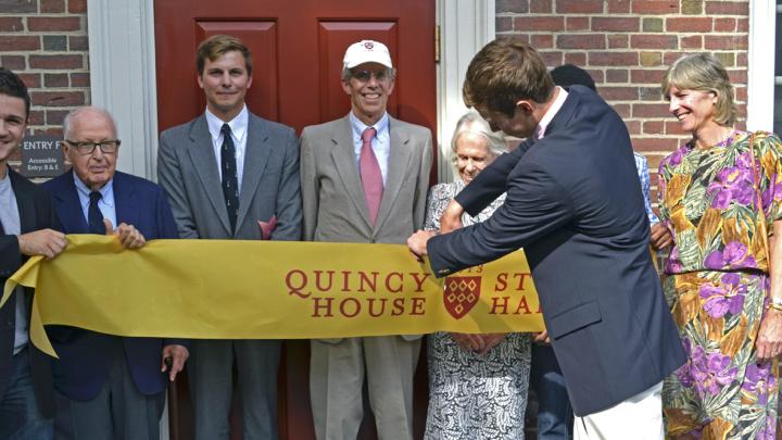 Geyser University Professor emeritus Henry Rosovsky (at left) and members of the Stone family, including grandson Robert Stone ’12, Gregg Stone ’75, J.D. ’79, Marion (Rockefeller) Stone, and Jennifer P. Stone ’80, M.D. ’86, together with Quincy residents Franco Iudiciani ’16 (far left) and Onyeka Nnaemeka ’16 (obscured at right), witnessed grandson Eric Green ’16 cut the ribbon that officially opened Stone Hall’s F entry.