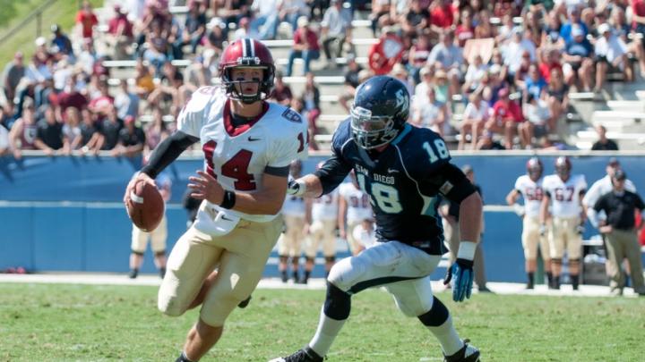 In his debut as Harvard’s starting quarterback, junior Conner Hempel (14) threw for 345 yards and four touchdowns. The pursuing San Diego defender is end Blake Oliaro.