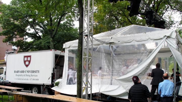 Workers assembled the cake under a tent to protect it from the rainy weather. A Harvard Dining Services truck brought over the individual sheet cakes, which form the 15-by-18-foot H-shaped cake. Sixty individual sheet cakes were baked, two per day, by Flour bakery and deep frozen at Harvard awaiting the day of the celebration.