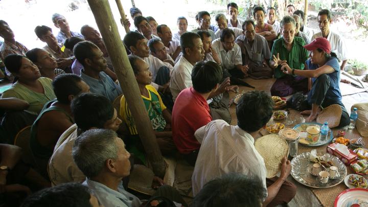 Debbie Aung Din Taylor (with red hat), co-founder of Proximity Designs, meets with villagers in A Phaung Gyi, in Dedaye township in the Ayeyarwaddy River Delta. Many of the villagers use crop loans provided by Proximity Designs to plant rice. It also provides agricultural advice, and now distributes a line of popular, low-cost solar lights (90 percent of Myanmar's rural households are not on an electrical grid). 