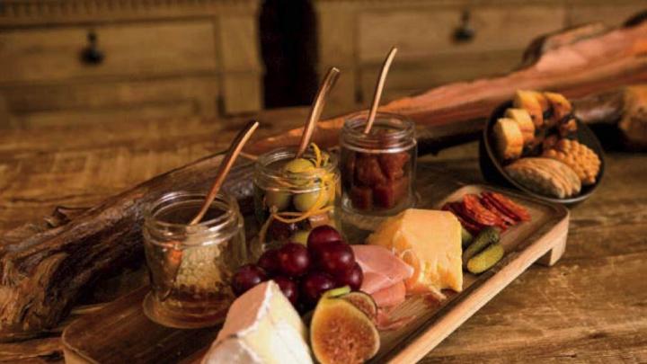 A platter of cheese, cured meats, and fruit