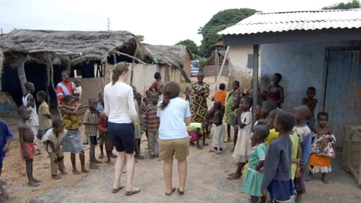 After the group's van broke down, Audrey White ’10 and Kim Kargman ’11 attempted to learn some traditional games from Ghanaian children. The children found the <em>obrunis'</em> ("foreigners") lack of skill amusing, says White.