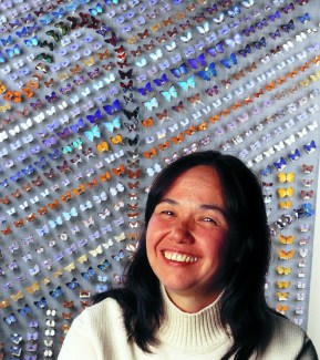 Naomi Pierce in front of a wall displaying hundreds of butterflies