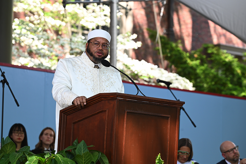 Imam Dr. Khalil Abdur-Rashid wearing white cap and robe delivers sermon to the audience