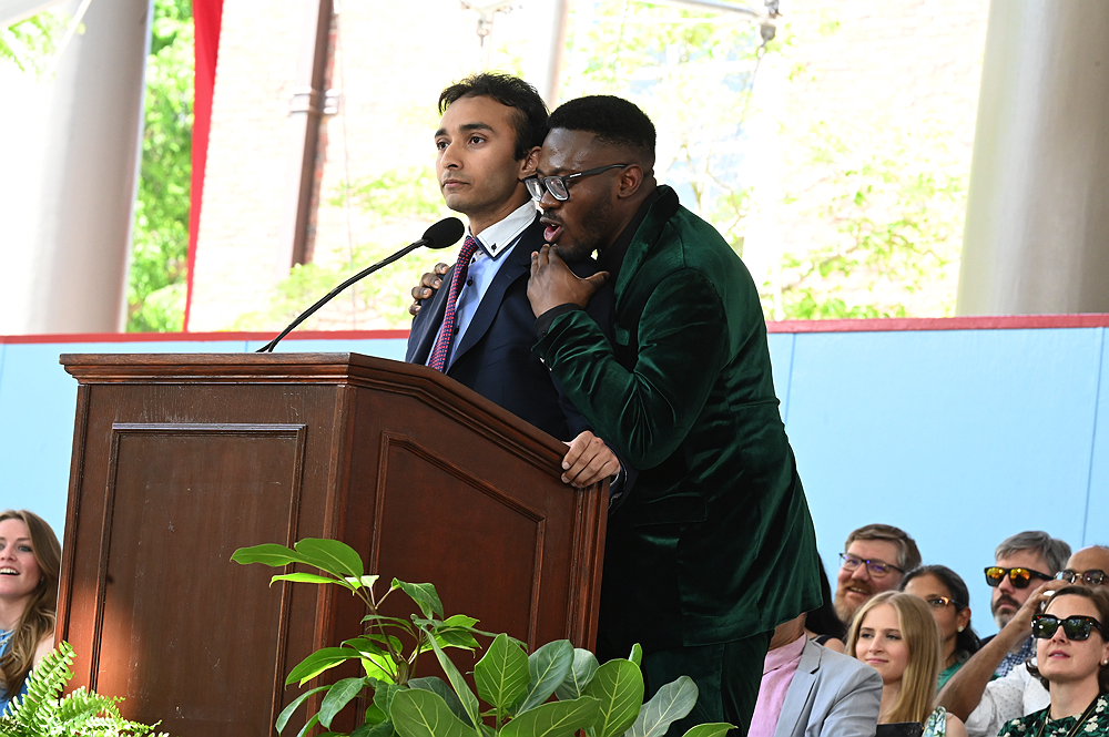 Two men speaking at podium 