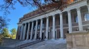 The facade of Widener Library with columns and steps with blue sky and trees