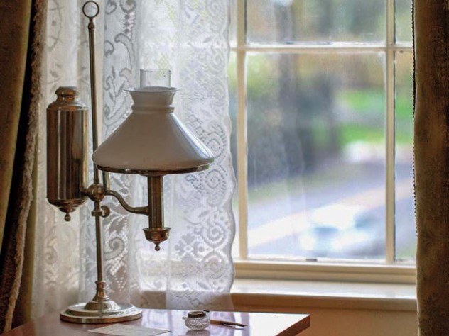 A replica of Dickinson’s small, square writing table sits near a window in her bedroom