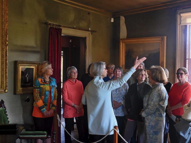 A tour party views works to art at The Evergreens