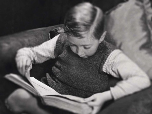 Photo of a young boy reading a book