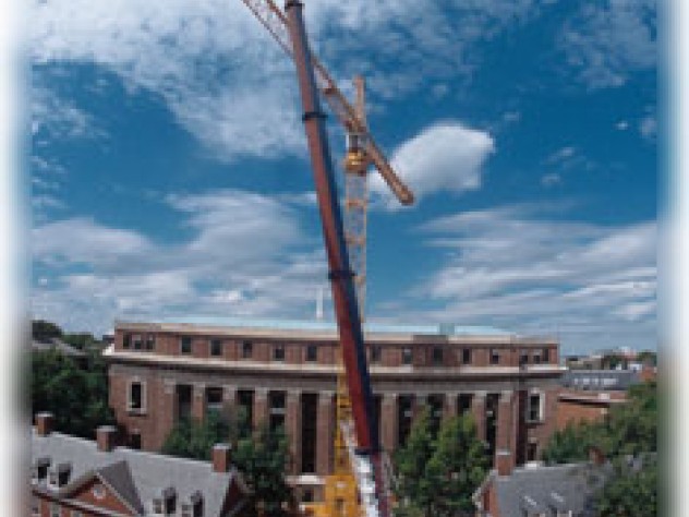 Photograph by Jon Chase It takes one to build one. To assemble a 180-foot-high crane behind Widener Library, the crane in the foreground carefully hoisted a 300-foot-long boom from Massachusetts Avenue, where it had been pieced together, into place on high. The July 9 maneuver was reminiscent of a docking in space. Anthony C. Ferranti ’46, observing from his camera store across the street, opined, “This is the most exciting thing that’s happened in Harvard Square in years.”