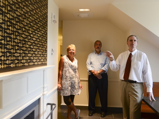 Jim Harrison Architect Stephen Kieran (at right), Quincy co-master Deborah Gehrke, and Harvard's senior director of project management Steve Needham, point out that on upper floors, in a gesture to returning alumni, a graphic designer mounted old room keys (now replaced with electronic cards for access to entryways, floors, and rooms) in eight different patterns; they are hung over fireplaces.