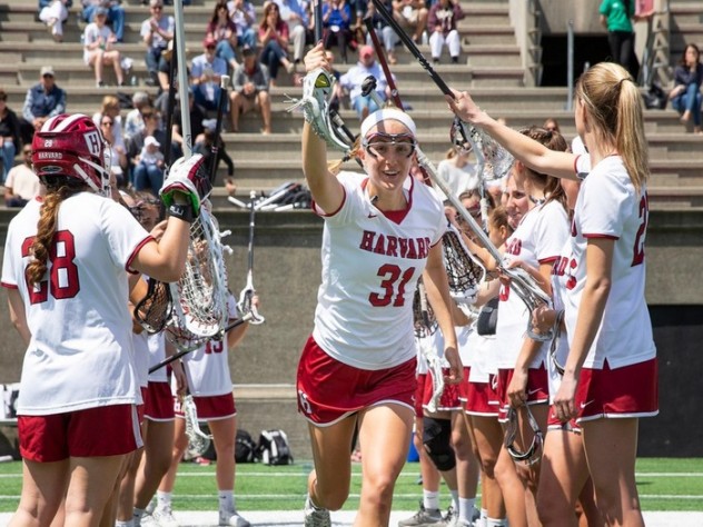 Photograph of Harvard women lacrosse players celebrating.
