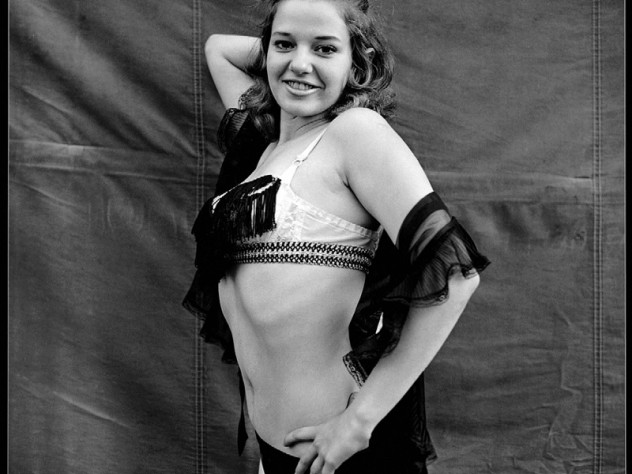 Photograph by Susan Meiselas/Magnum Photos Essex Junction, Vermont, 1973. “We aren’t professional show girls, we’re prostitutes pretending to be show girls. But what else can I do? The only thing I know how to do is dance. I can’t be a teacher; I don’t have the patience. I couldn’t work as a nurse, because I get too emotionally involved. The only thing I can do is dance or be a waitress. Do you want me to be a waitress for the rest of my life?” —Lena, from the book <em>Carnival Strippers</em>