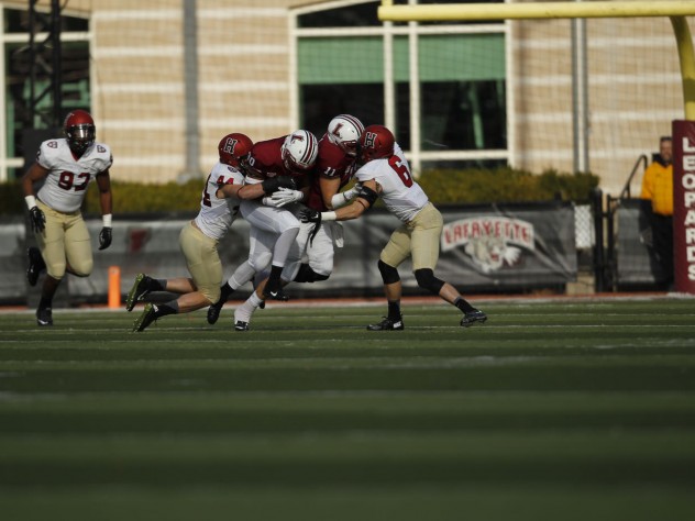 Even with Quinn Smith (11) helping out, Leopard runner DeSean Brown (30) was unable to get past the Crimson senior defensive back double team of Sean Ahern (6) and Scott Peters (44).