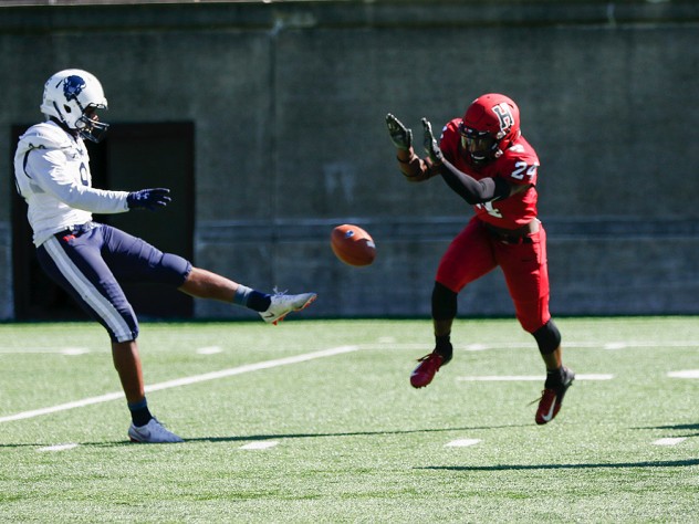 Harvard freshman Khalil Dawsey blocks the punt of Howard's Isaiah Moore.