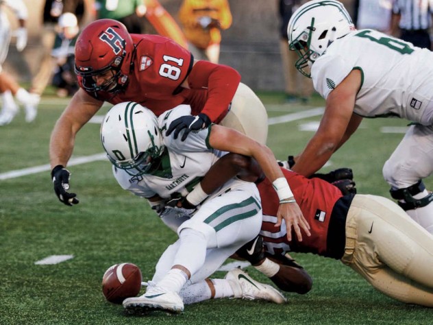 Photograph of Harvard sophomore defensive lineman Truman Jones (90) sacking and stripping the ball from Dartmouth quarterback Derek Kyler