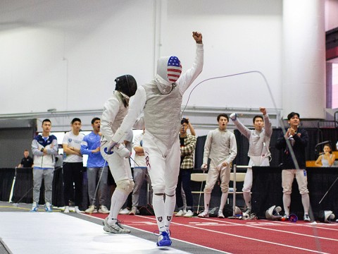 A fencer walks away from his opponent, holding up a fist