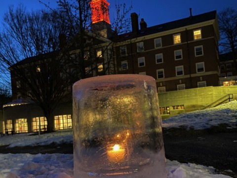 Close-up image of an "ice lantern" (a light set in an ice casing) in the snow on Radcliffe Quad