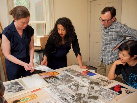 Hinton arranges materials for the Angela Davis exhibit with (from left) Radcliffe arts program manager Meg Rotzel, gallery coordinator Joe Zane, and Pforzheimer fellow Jackie Wang.