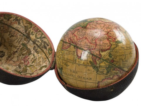 A photograph of an eighteenth-century, three-inch pocket globe in its open case