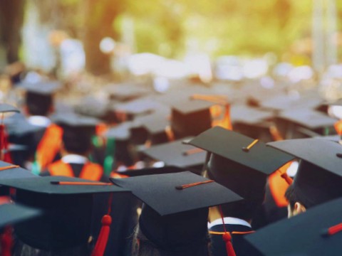 Photograph of students in caps and gowns graduating from college