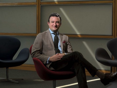 Photograph of Professor Eric Nelson, seated, wearing a coat and tie