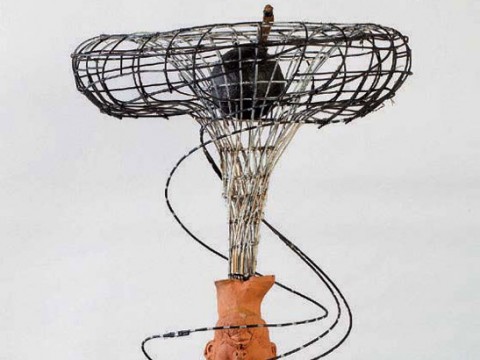 Clay head over wooden pill bottles with wires representing the impact of opioids on human beings