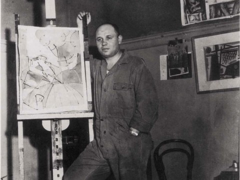 Photograph of artist Romare Bearden standing by an easel c. 1940