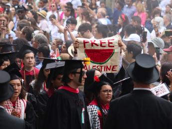 Protestors walking out of Harvard Commencement 