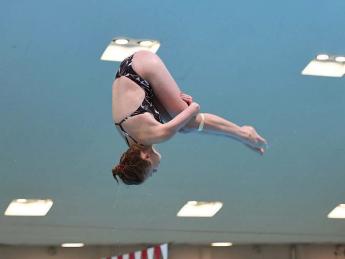 Georgina Milne flies through the air, flipping toward the water.