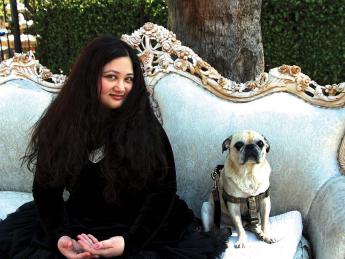 Author Gabrielle Zevin seated on a sofa in Los Angeles with her dog Nico