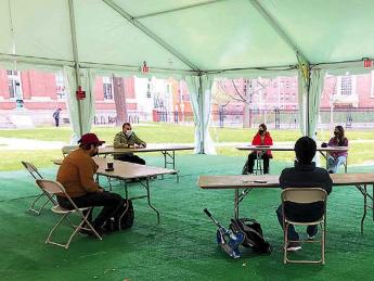 Photograph of teaching a playwriting class under a tent outdoors