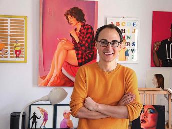 David Andersson standing among his colorful painted portraits