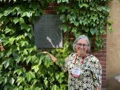 Meg Campbell ’74 stands in front of a plaque honoring Annie Sullivan.