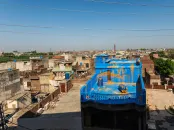 view of rooftop buildings and a colorful roof painted blue and gold as an art display