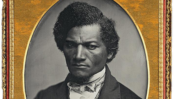 Oval black and white image of Frederick Douglas with gold frame around image