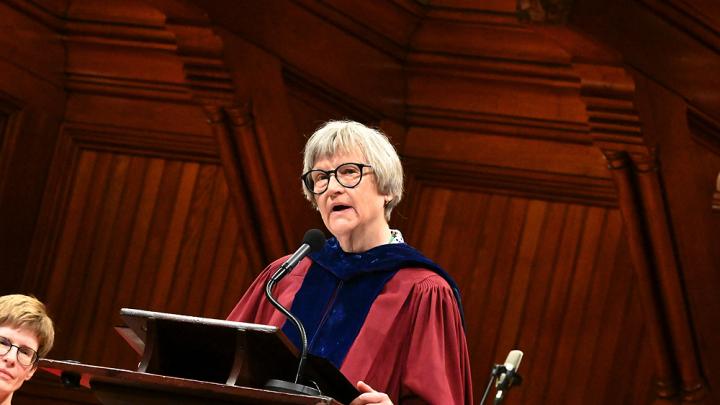 Drew Gilpin Faust in robes at the podium in Sanders Theater