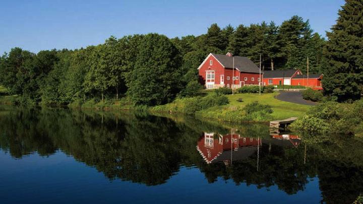 Iconic red-painted River Bend Farm Visitor Center by the Blackstone River and canal